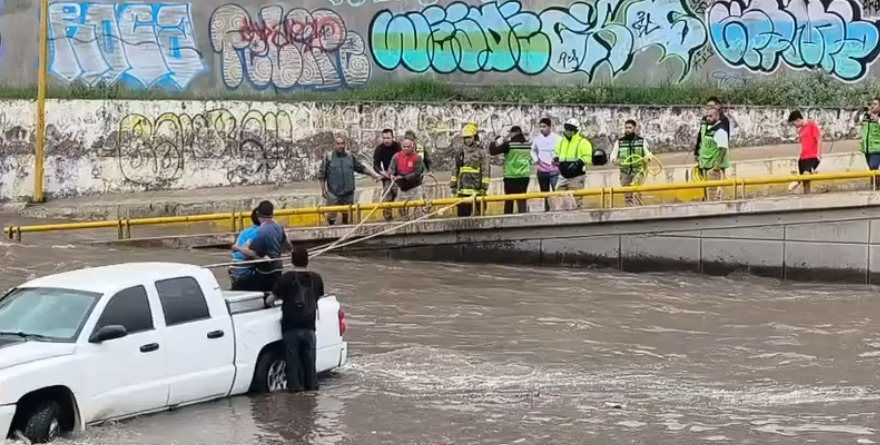 Rescatan a tres necios de morir ahogados dentro de su camioneta
